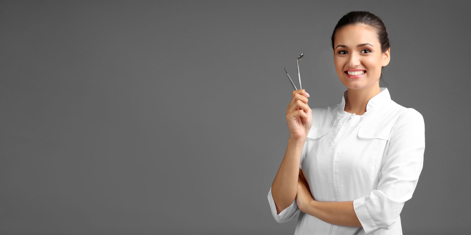 dentist smiling and holding tools