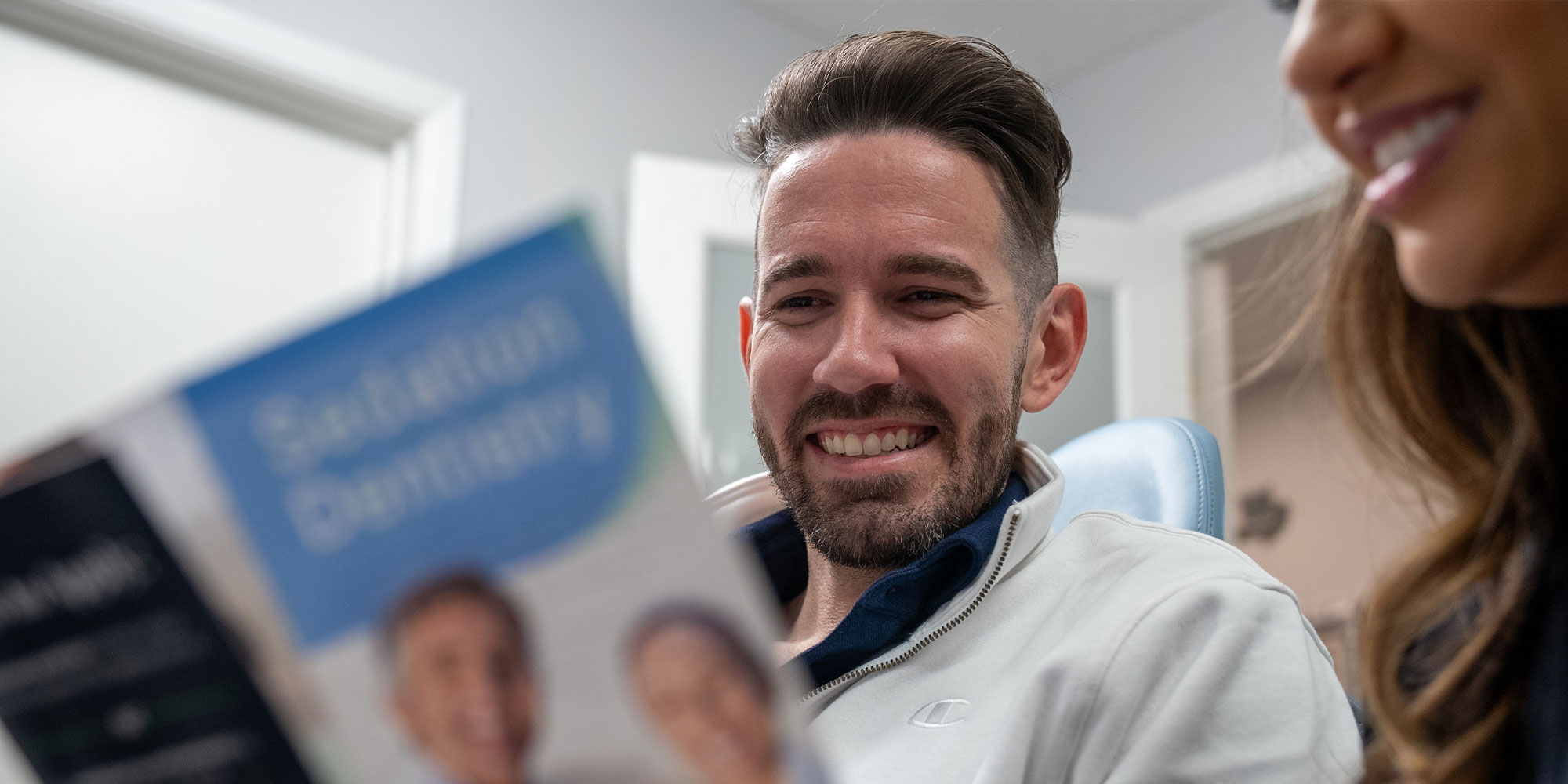 patient smiling brightly while going over finance information