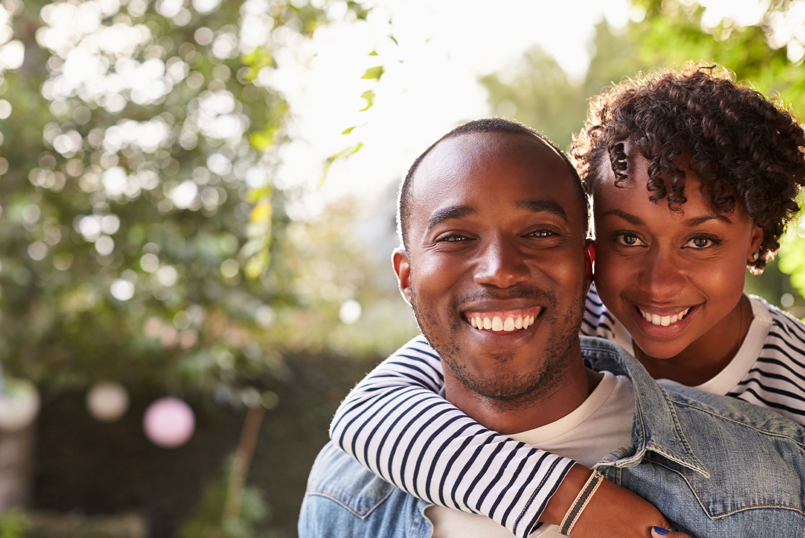 couple smiling brightly while being outside in the sun