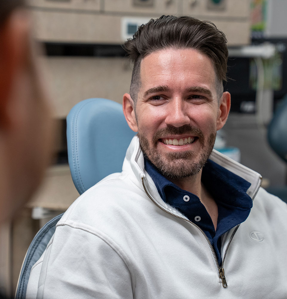 patient smiling brightly while listening in on dental procedure information